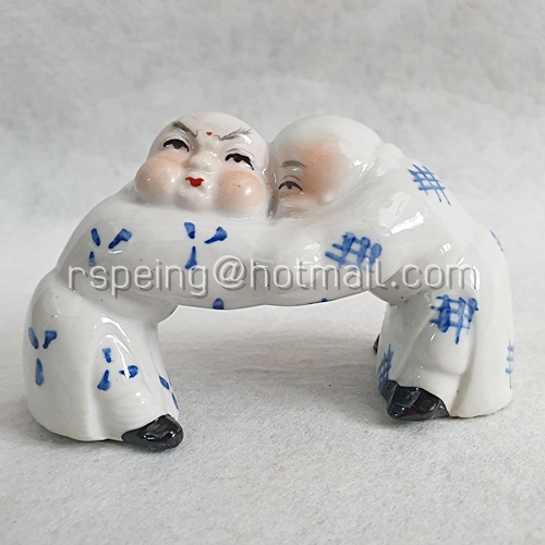 นักบวชจีน เซรามิก ในท่าจับมือเอาหัวชนกัน
