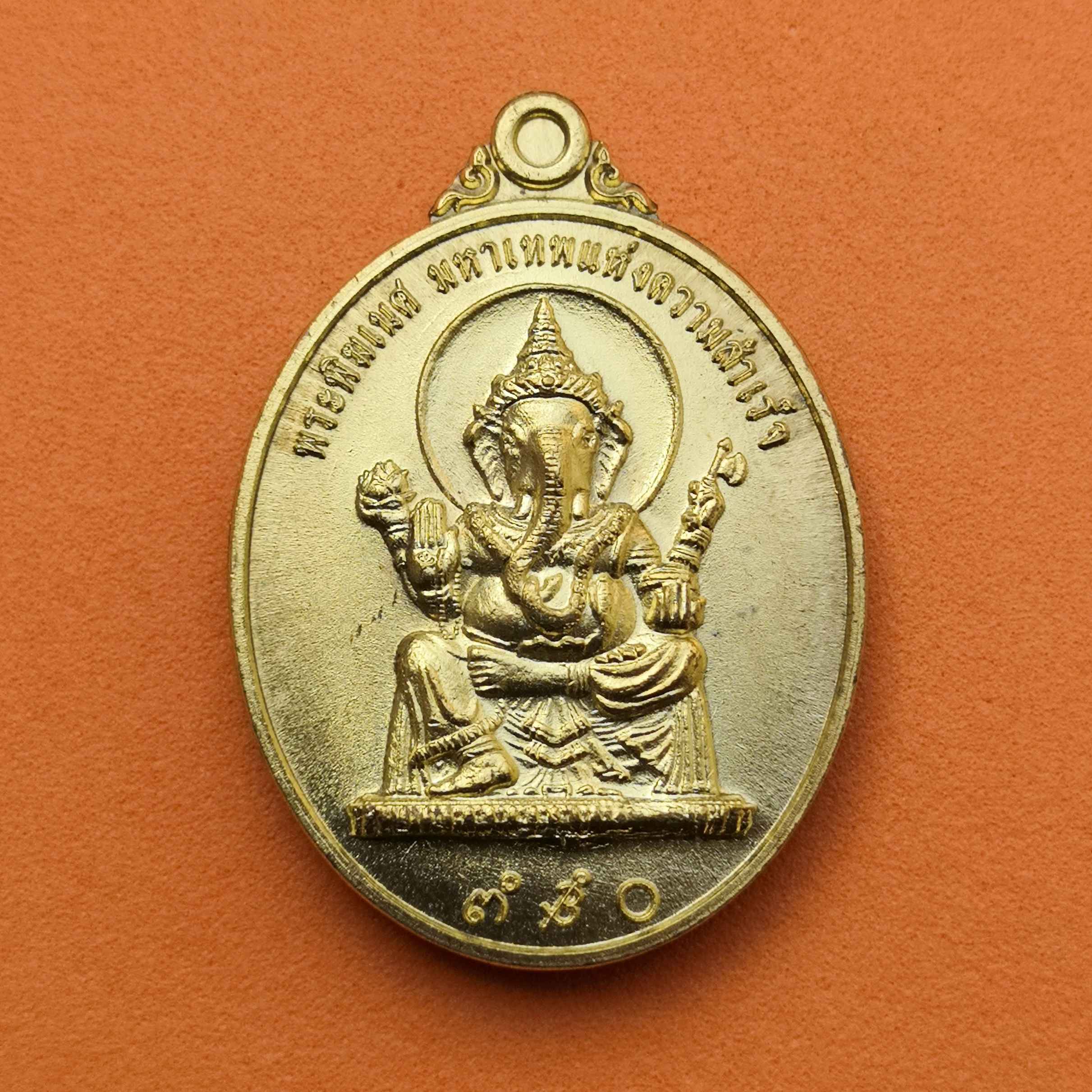 เหรียญ พระพิฆเนศ มหาเทพแห่งความสำเร็จ หลัง ท้าวกุเวร เทพเจ้าแห่งความร่ำรวย วัดมัชฌิมาวาสวรวิหาร จังหวัดสงขลา พศ 2558 เนื้อทองเหลือง สูง 3 เซน