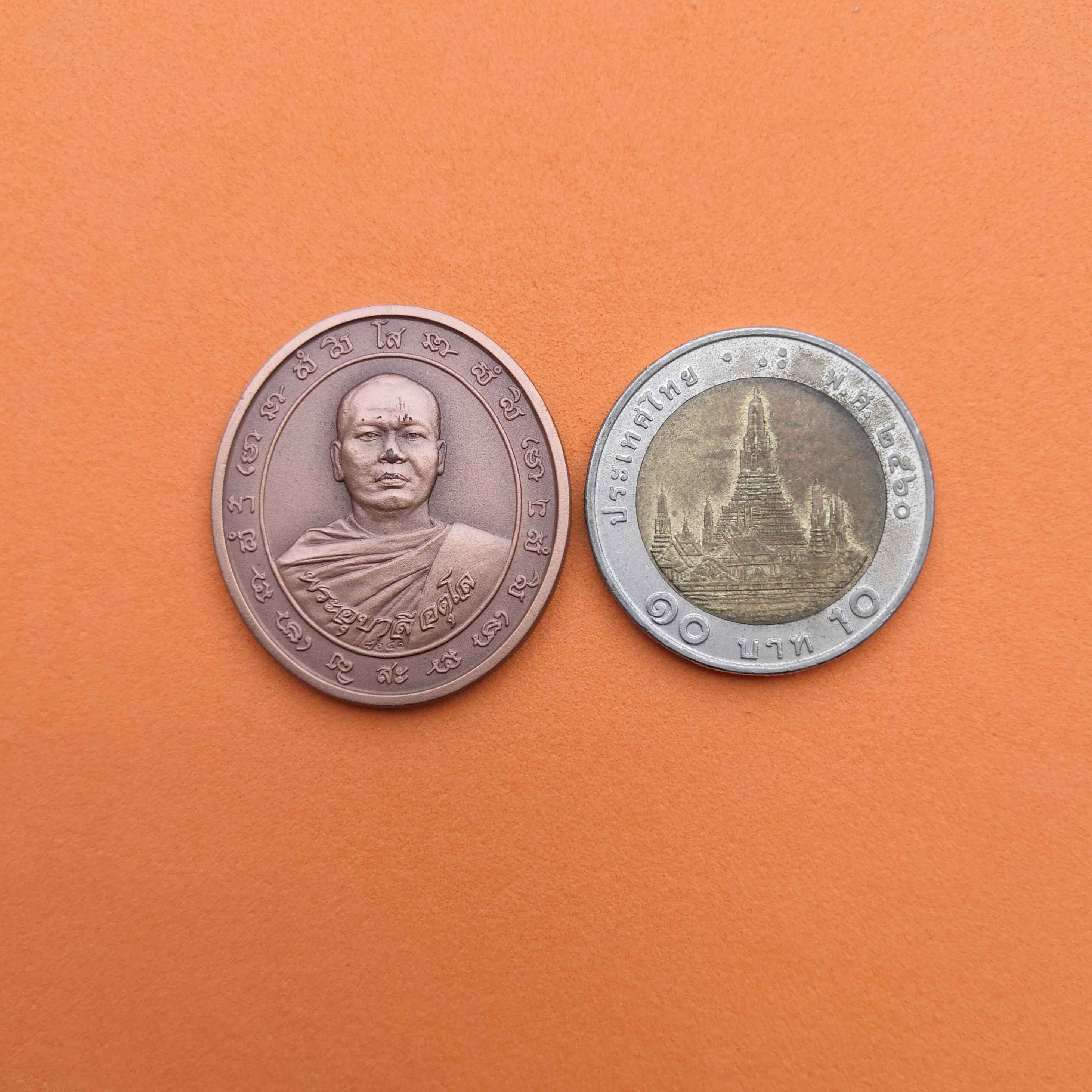 เหรียญพระอุบาลี อตุโล ที่ระลึกสร้างมหาวิหารสมเด็จองค์ปฐม พระพุทธสิกขีทศพลที่ 1 วัดจันทร์ตะวันตก อ.เมือง จ.พิษณุโลก รุ่น 2 พ.ศ.2554 เนื้อทองแดงรมดำ สูง 3 เซน บล็อกกษาปณ์ ***ด้านหน้ามีรอยตามภาพนะครับ***