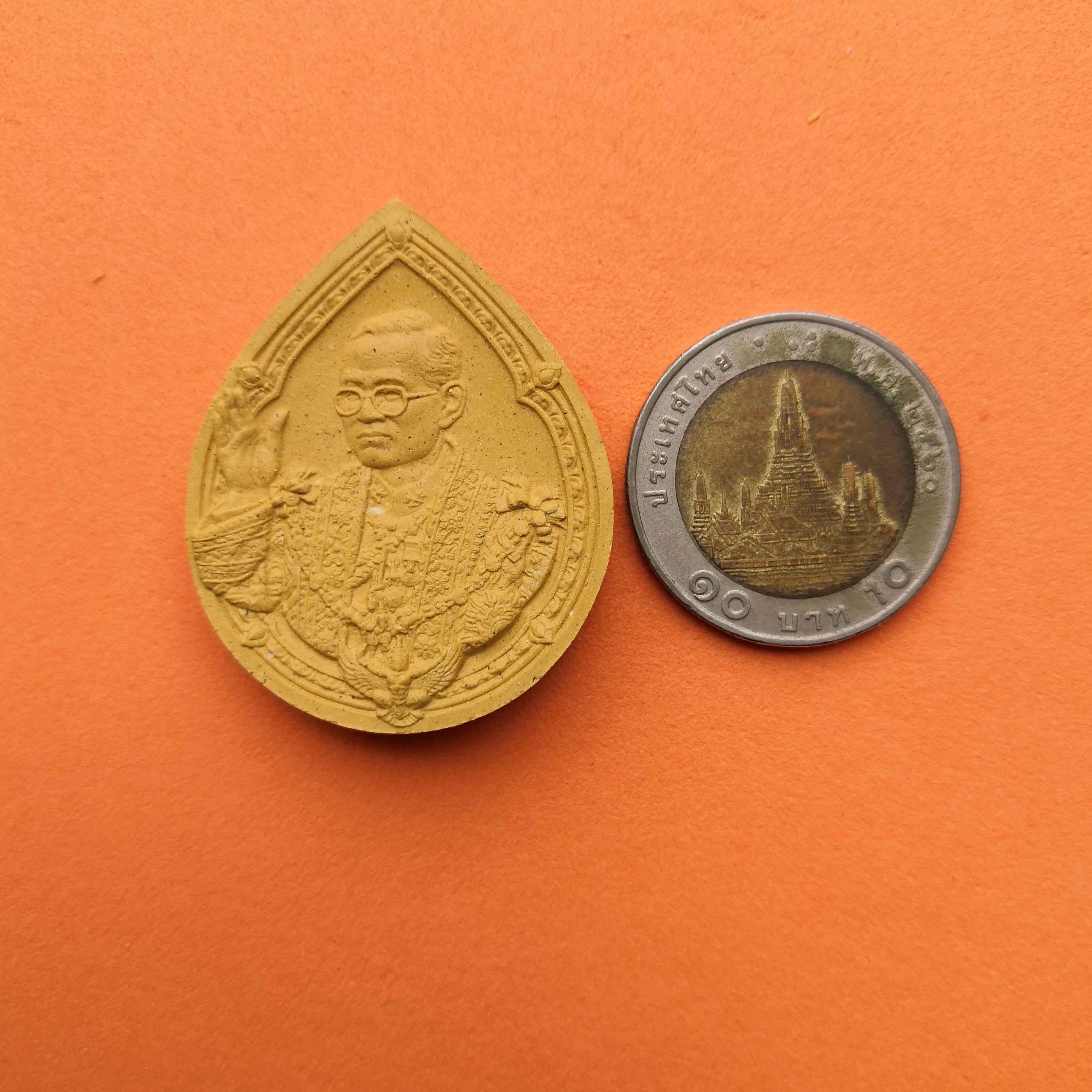 เหรียญเนื้อผงทรงหยดน้ำ มวลสารมงคล เรารักพระเจ้าอยู่หัว หลังตราครองราชย์ 60 ปี จัดสร้างโดยมูลนิธิคิงเพาเวอร์