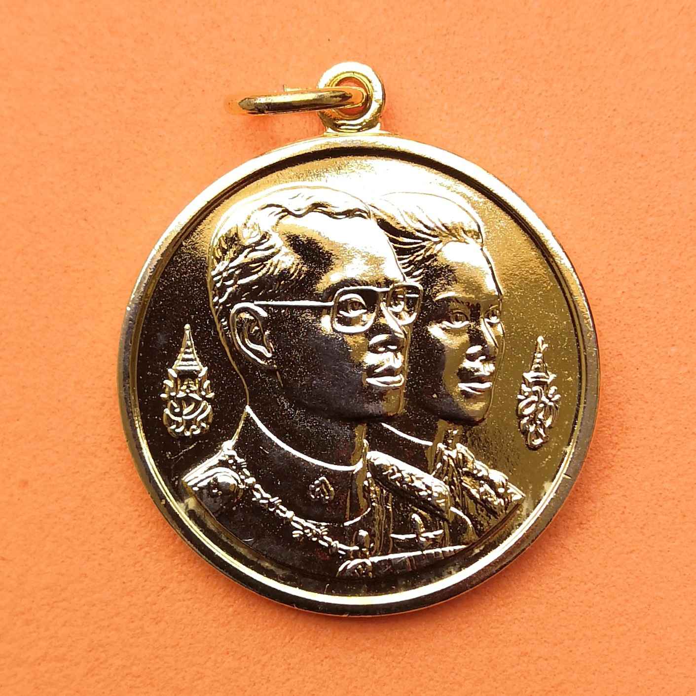 เหรียญในหลวง รัชกาลที่ 9 คู่สมเด็จพระราชินี ที่ระลึกเนื่องในการก่อสร้างพระมหาธาตุเจดีย์ นภเมทนีดล และ นภพลภูมิสิริ กองทัพอากาศสร้างน้อมเกล้าฯ ถวายในวโกาสเฉลิมพระชนมายุ 60 พรรษา เนื้อกะไหล่ทอง ขนาด 2.6 ซม