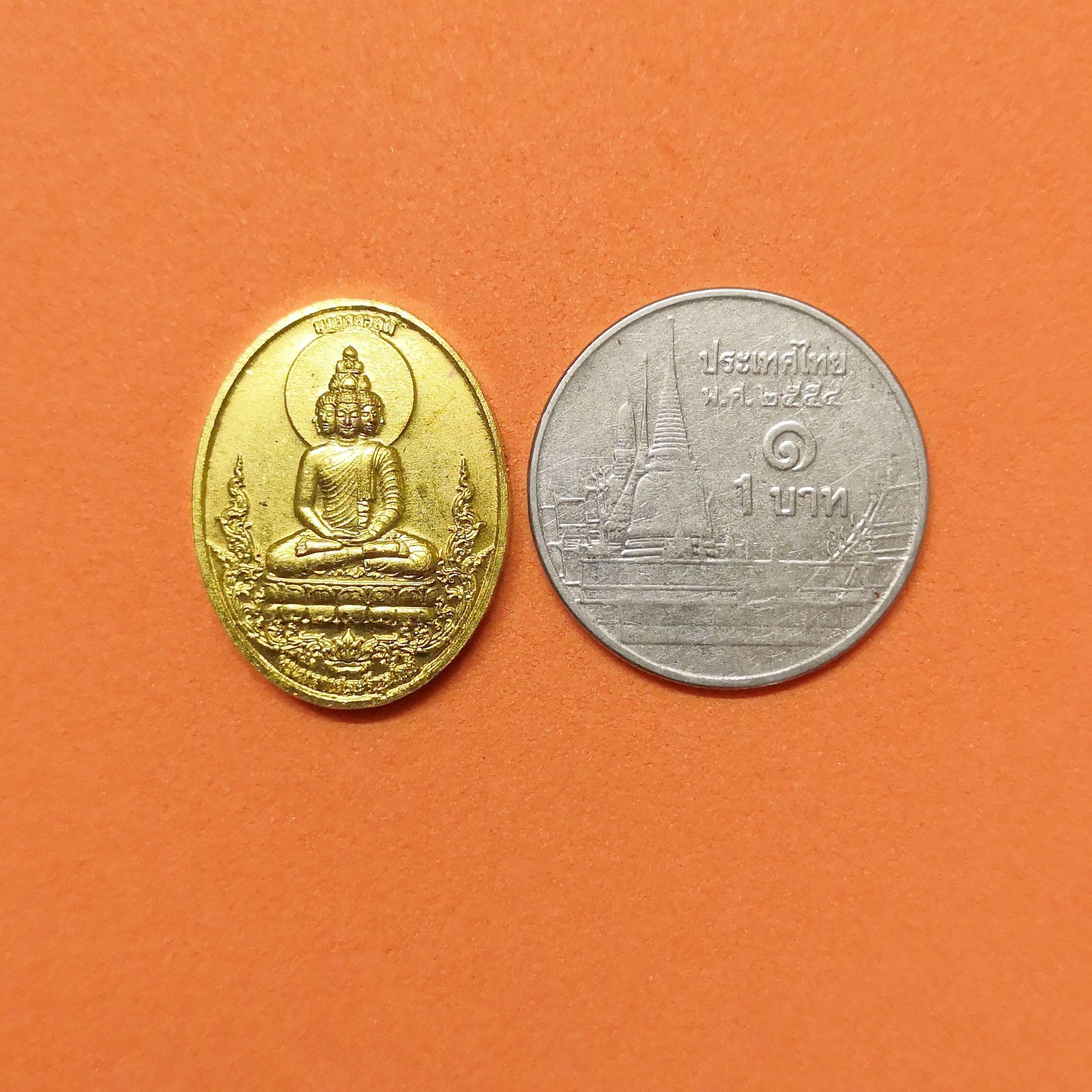 เหรียญพิมพ์เล็ก สูง 2 เซน พระเศรษฐี พระคลังมหาสมบัติ หลัง พระเศรษฐีนวโกฎิ รุ่นมงคลสวัสดิ์ วัดมงคลสวัสดิ์ ชลบุรี มหามงคลที่ระลึกประจําปี 2565 โดยอาจารย์ ลักษณ์ เรขานิเทศ สถาบันพยากรณ์ศาสตร์ เนื้อกะไหล่ทอง พร้อมกล่องเดิม