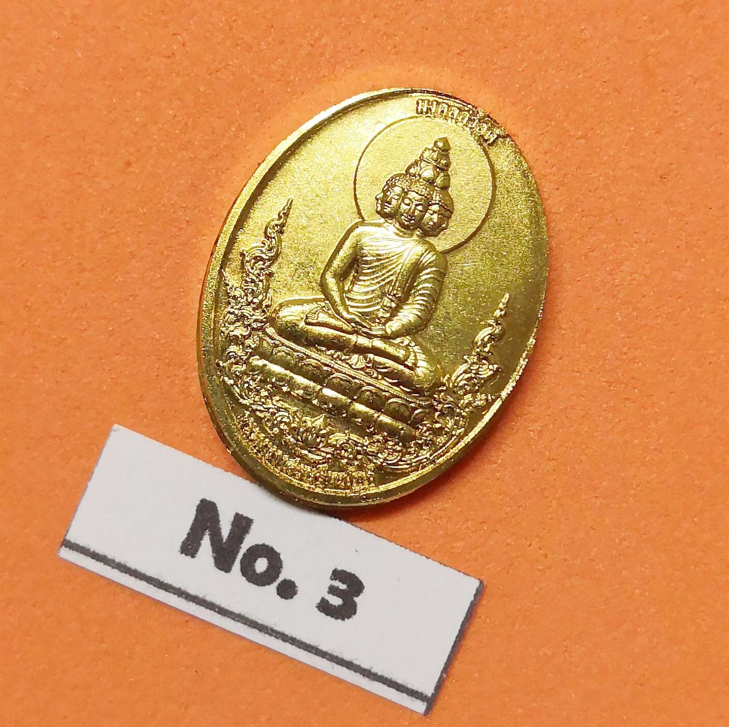 เหรียญพิมพ์เล็ก สูง 2 เซน พระเศรษฐี พระคลังมหาสมบัติ หลัง พระเศรษฐีนวโกฎิ รุ่นมงคลสวัสดิ์ วัดมงคลสวัสดิ์ ชลบุรี มหามงคลที่ระลึกประจําปี 2565 โดยอาจารย์ ลักษณ์ เรขานิเทศ สถาบันพยากรณ์ศาสตร์ เนื้อกะไหล่ทอง พร้อมกล่องเดิม