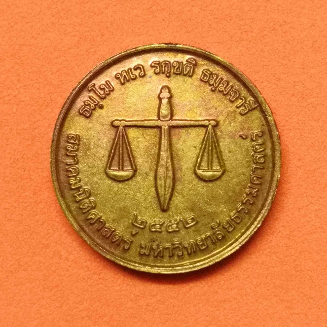 เหรียญเล็ก ขนาด 1.7 เซน พระพุทธโลกนิติธรรมเทสก์ หลัง ตาชั่ง สมาคมนิติศาสตร์ มหาวิทยาลัยธรรมศาสตร์ พศ 2552 เนื้อทองแดง