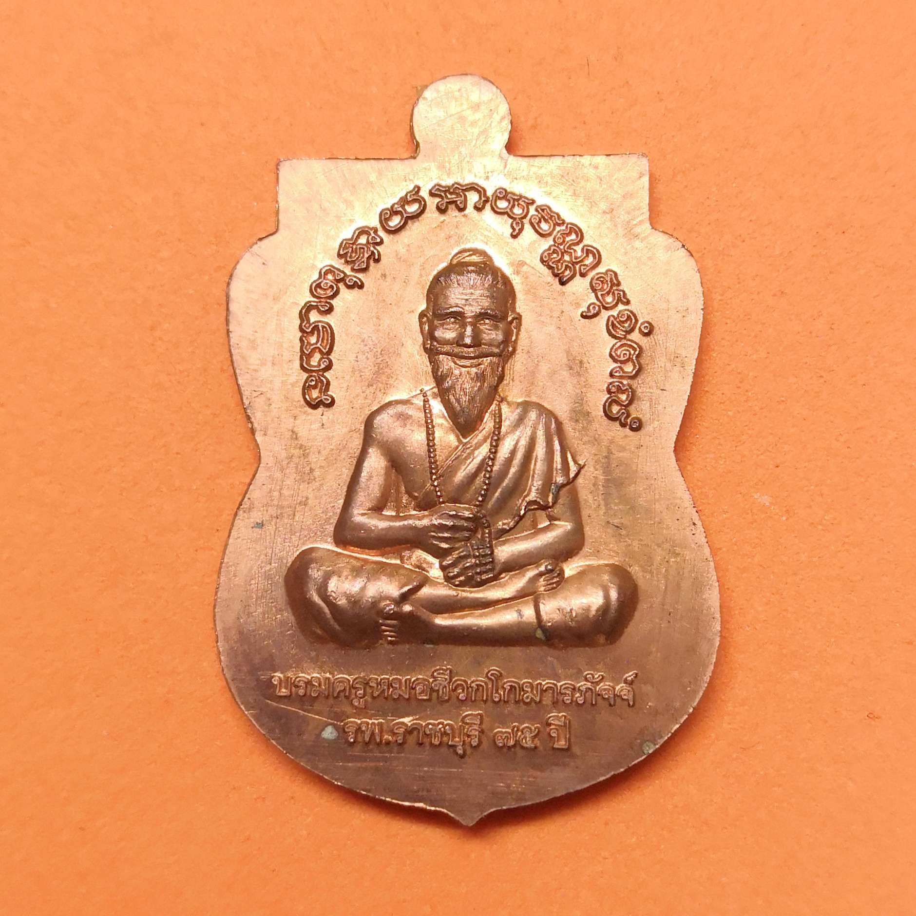 เหรียญเสมา พระพุทธนิรโรคันตราย ชัยวัฒน์จตุรทิศราชบุรี ด้านหลัง บรมครูหมอชีวกโกมารภัจจ์ ที่ระลึกครบ 75 ปี โรงพยาบาลราชบุรี พศ 2560 เนื้อทองแดง สูง 3.2 เซน