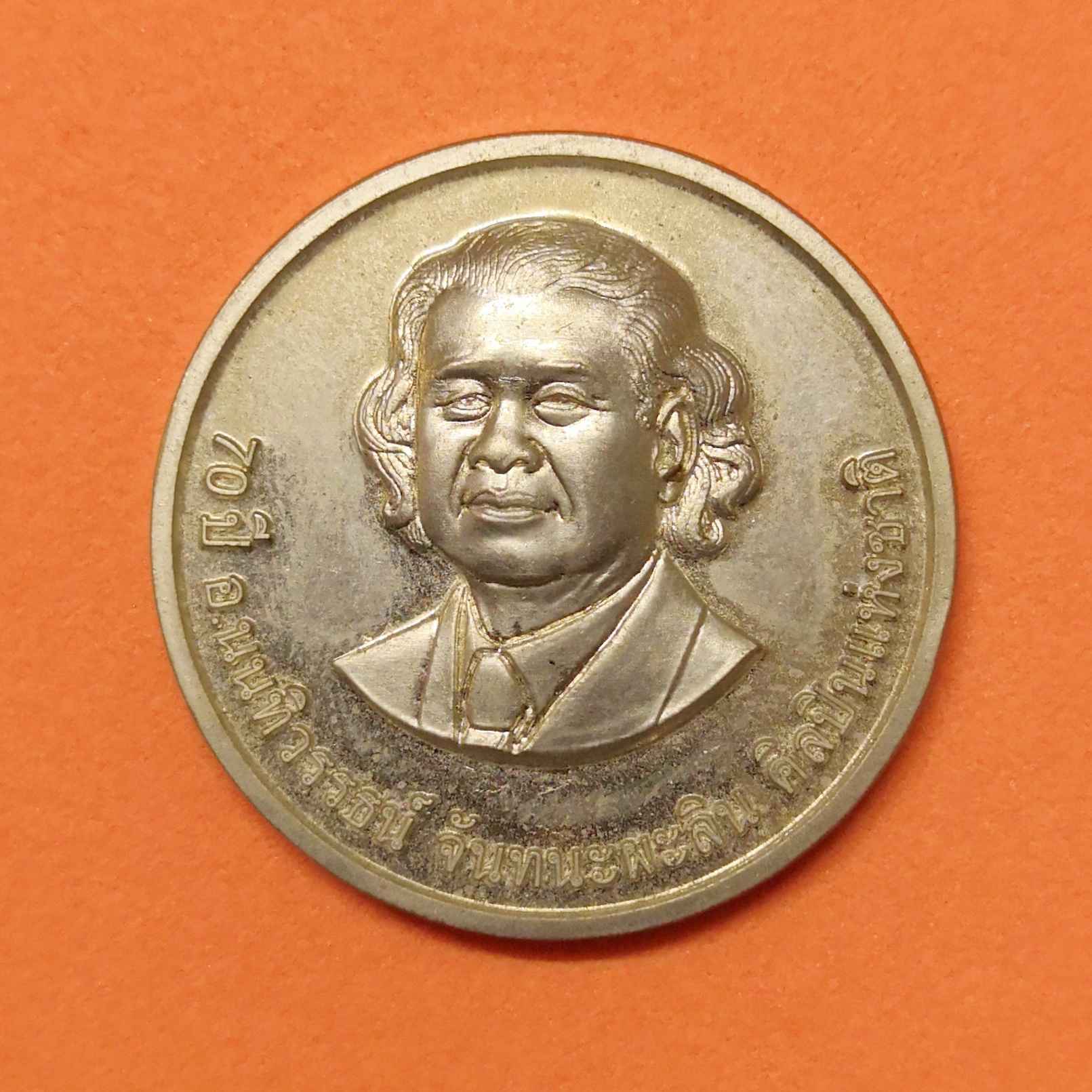 เหรียญที่ระลึก 70 ปี ศาสตรเมธี นนทิวรรธน์ จันทนะผะลิน ด้านหลัง งานประติมากรรม FATHER AND CHILD ศิลปินแห่งชาติสาขาทัศนศิลป์ ผู้ออกแบบและทำต้นแบบเหรียญ พระมหาชนก เนื้อนิกเกิล ขนาด 3 เซน